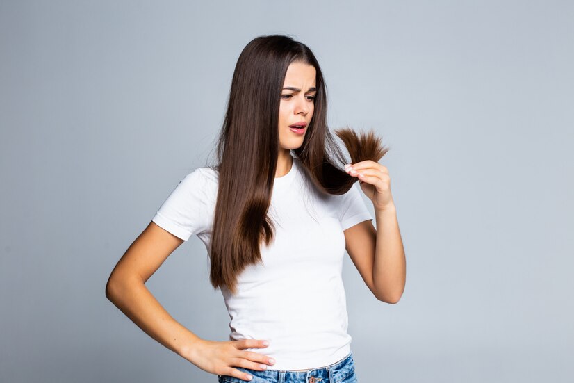 sad-girl-looking-her-damaged-hair-isolated-white_231208-1621